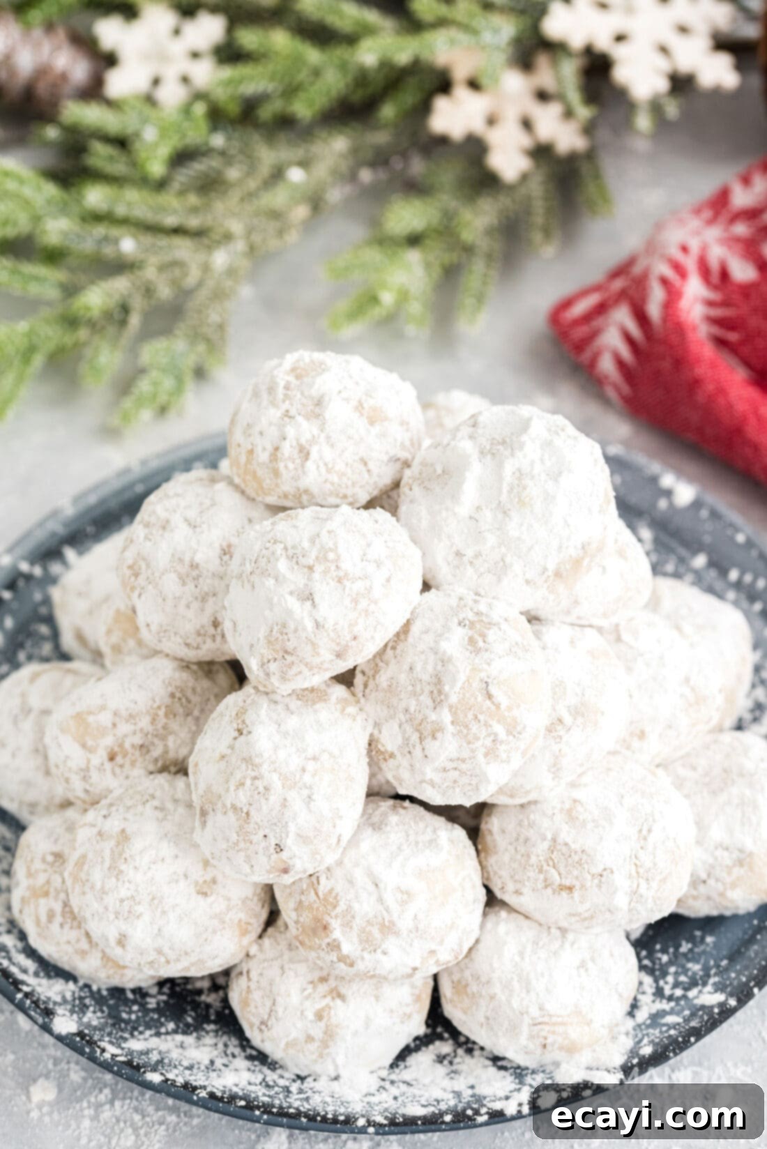 Snowball Cookies 3 A plate piled high with freshly baked and sugar-dusted snowball cookies, ready to be enjoyed by friends and family
