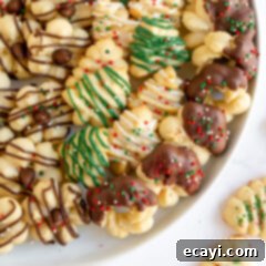 Spritz Cookies 15 A festive plate showcasing a variety of homemade Spritz cookies, each with intricate designs and delicious toppings, ready for holiday enjoyment.