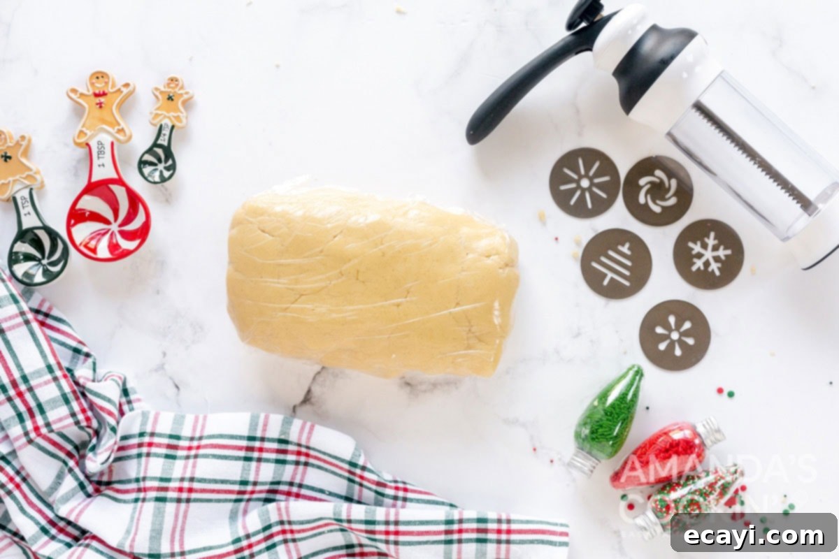 Spritz Cookies 5 Spritz cookie dough wrapped tightly in plastic wrap, chilling in the refrigerator to achieve perfect consistency.