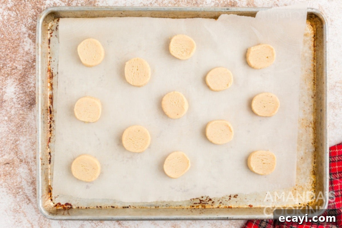Velvet Eggnog Cookies 9 Unbaked eggnog cookie slices arranged on a parchment-lined baking sheet