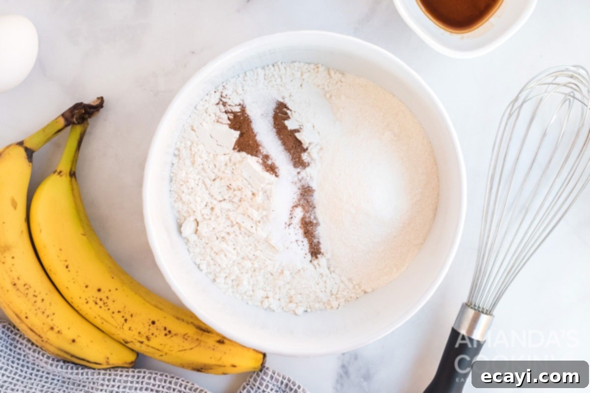 Soft-Baked Banana Cookies 6 Dry ingredients like flour, spices, and pudding mix being whisked together in a bowl