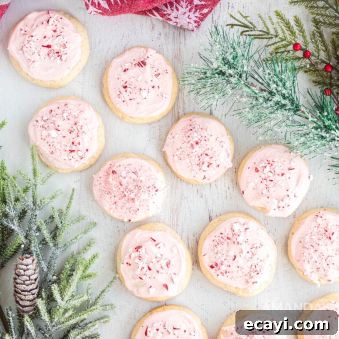 The 2020 Christmas Cookie Countdown: Twelve Days of Sweet Delights 8 Soft pink frosted peppermint cookies with crushed candy canes, on a festive plate.