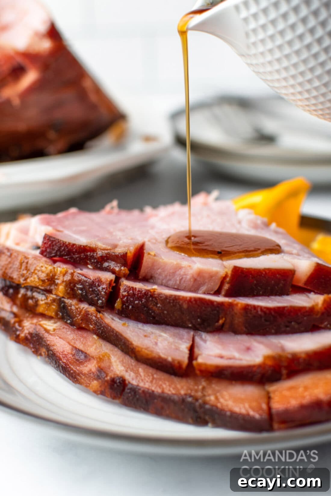 Zesty Orange Bourbon Glazed Ham 3 pouring glaze on ham slices