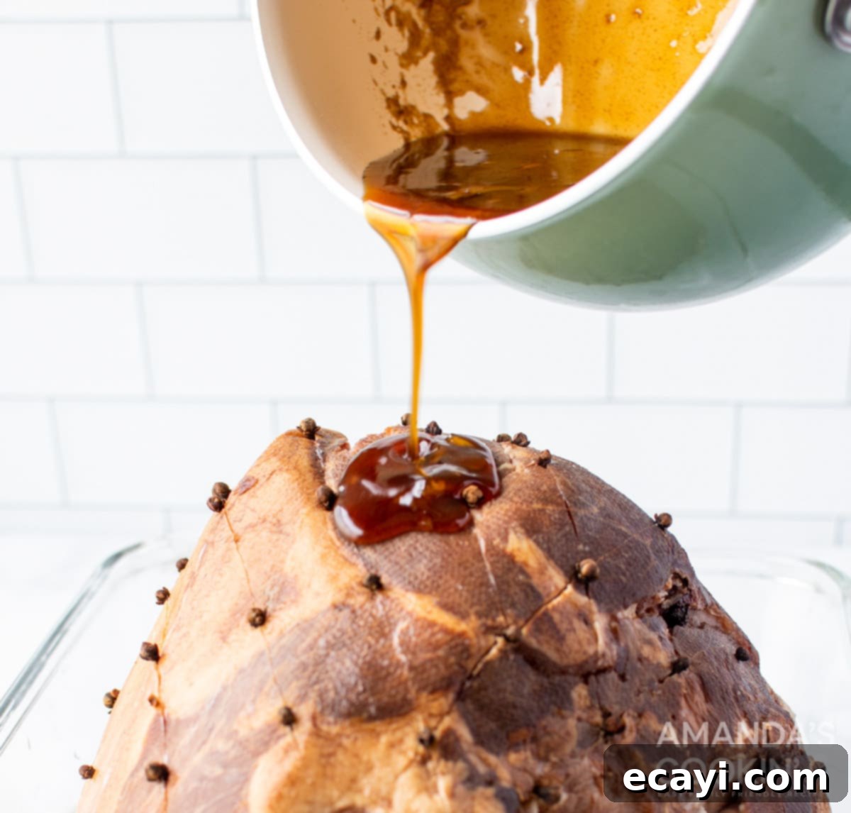 Zesty Orange Bourbon Glazed Ham 6 pouring glaze on ham