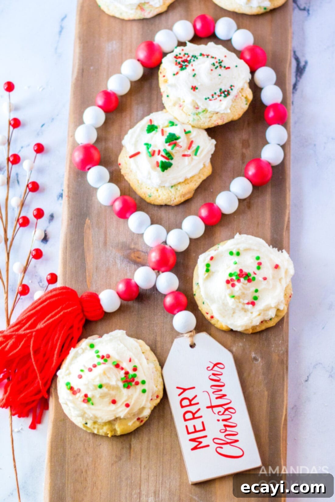 Festive Cake Batter Bites 3 Frosted cake mix cookies with holiday sprinkles on a wooden cutting board