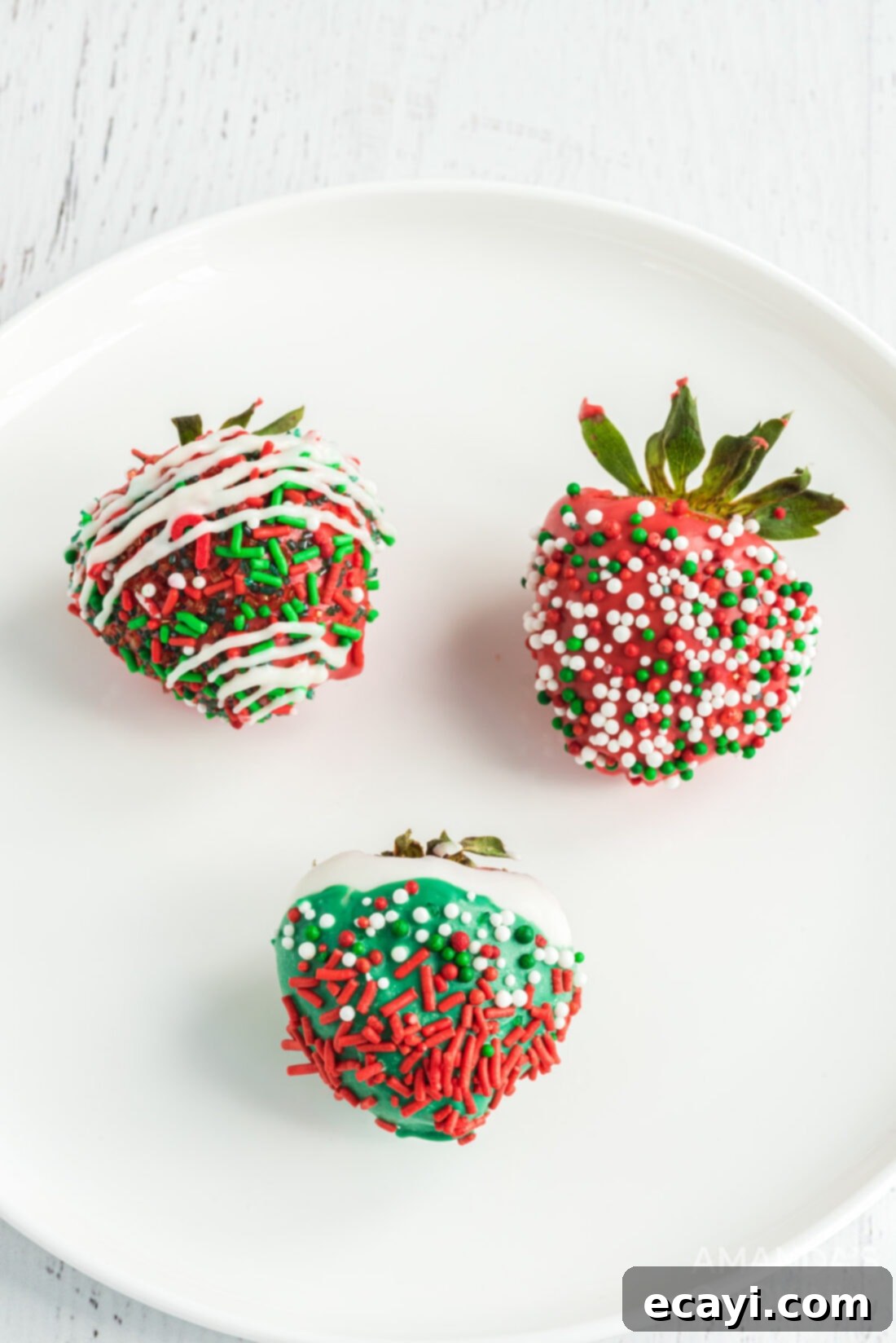 Merry Berry Chocolate Treats 2 Christmas themed chocolate covered strawberries adorned with red and green sprinkles and chocolate drizzles