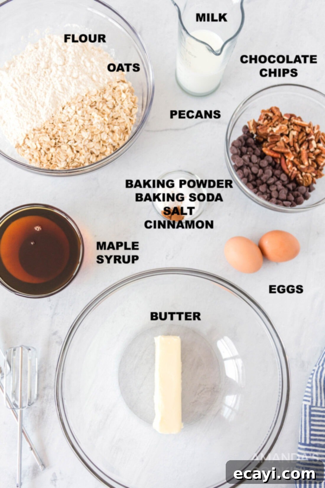 Chewy Oat Delights 4 Various labeled ingredients for oatmeal cookies, including butter, eggs, maple syrup, milk, oats, flour, baking powder, baking soda, salt, cinnamon, chocolate chips, and pecans