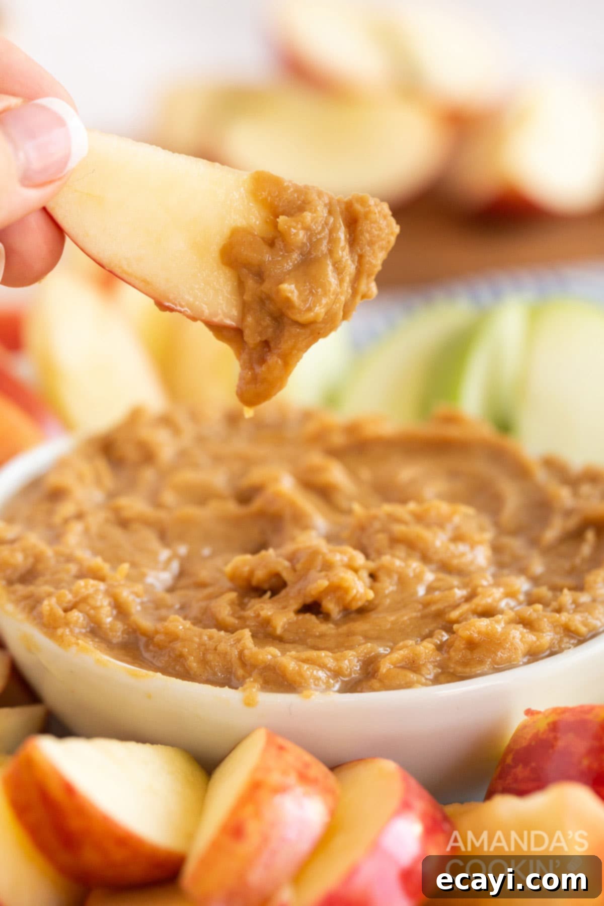 Creamy Peanut Butter Apple Delight 2 someone holding an apple slice covered with peanut butter dip