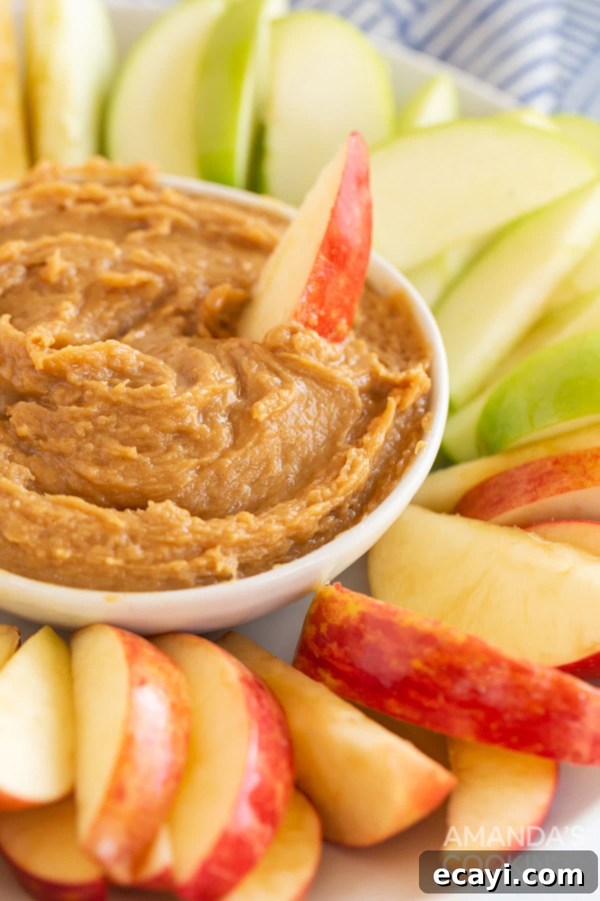 Creamy Peanut Butter Apple Delight 3 bowl of peanut butter fruit dip surrounded by apple slices on a plate