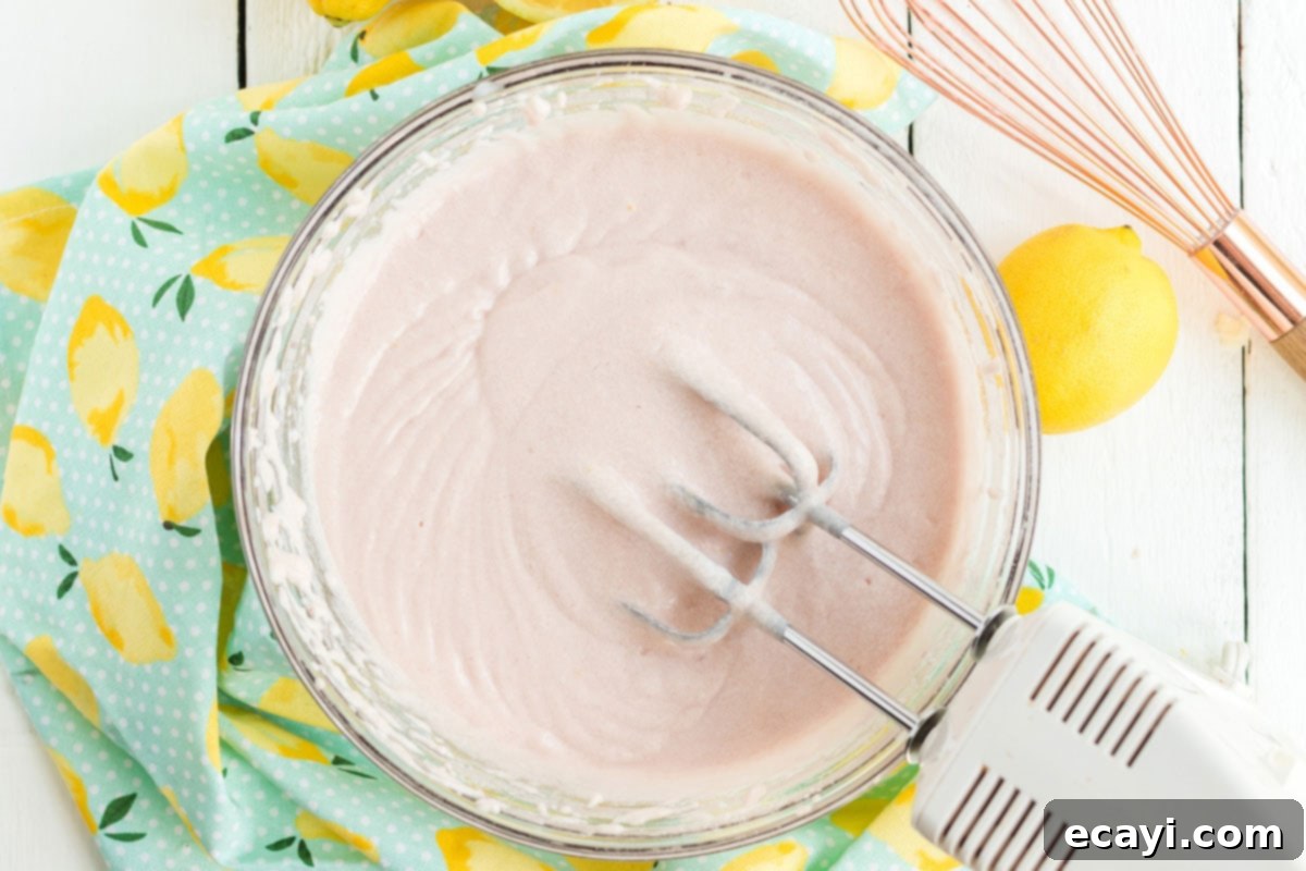 Sparkling Pink Lemonade Cake 9 A bowl filled with smooth, light pink cake batter, ready to be poured into baking pans.