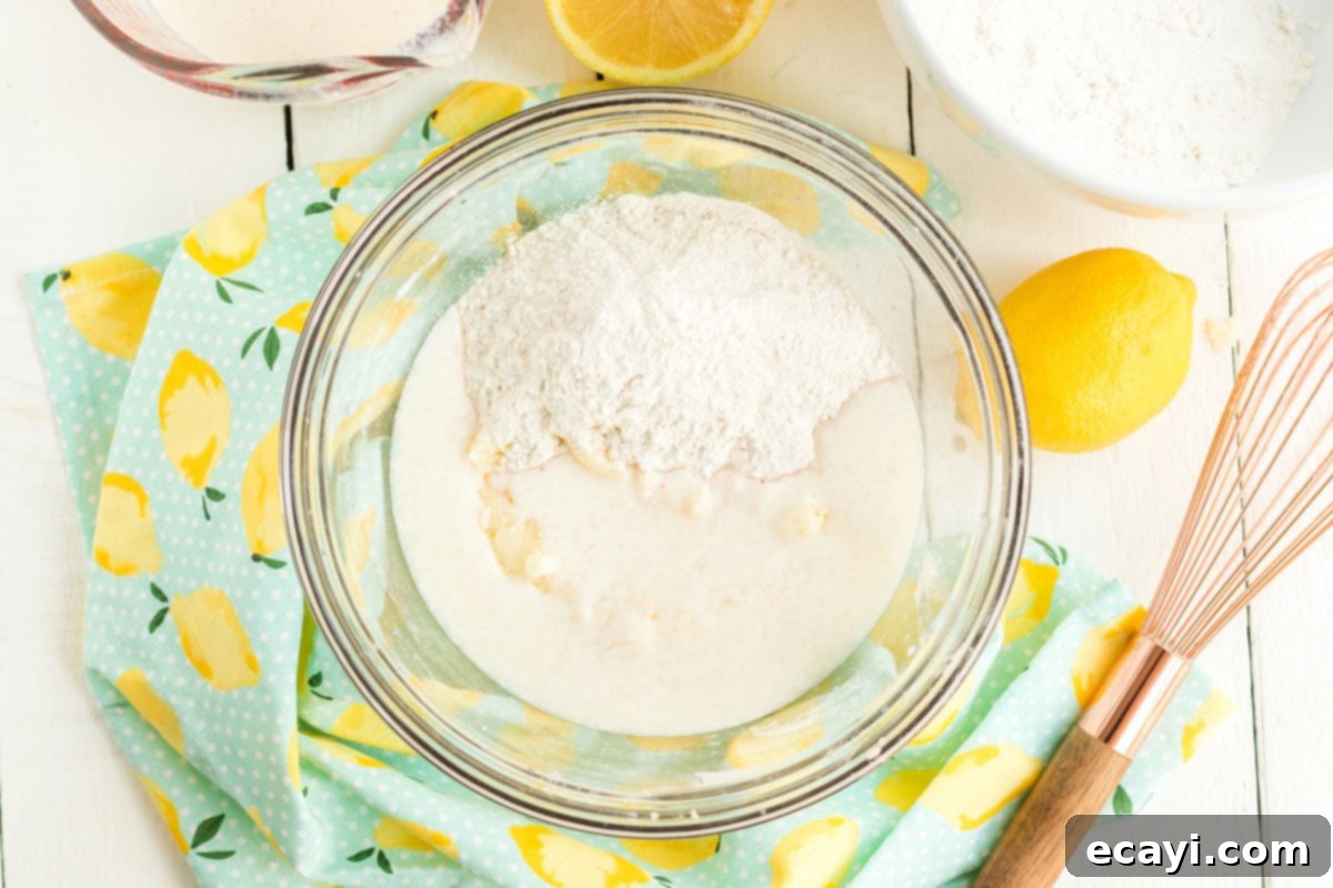 Sparkling Pink Lemonade Cake 8 A mixing bowl filled with cake ingredients, showing the gradual incorporation of wet and dry components for a smooth batter.