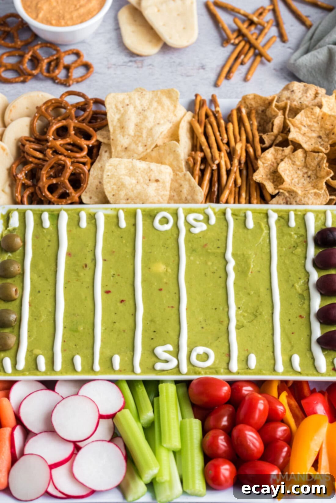 Game Day Grazing Platter 2 Vibrant football party tray featuring fresh guacamole, an assortment of crunchy vegetables, and savory crackers, perfect for game day snacking.