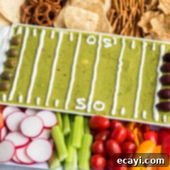 Game Day Grazing Platter 10 A beautifully presented football party tray, featuring guacamole, hummus, French onion dip, and various dippers, arranged for game day.