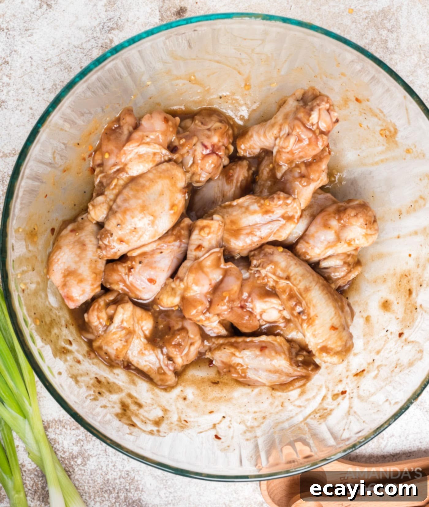 Inferno Wings 6 Adding chicken wings to the tamarind marinade mixture and tossing to coat thoroughly