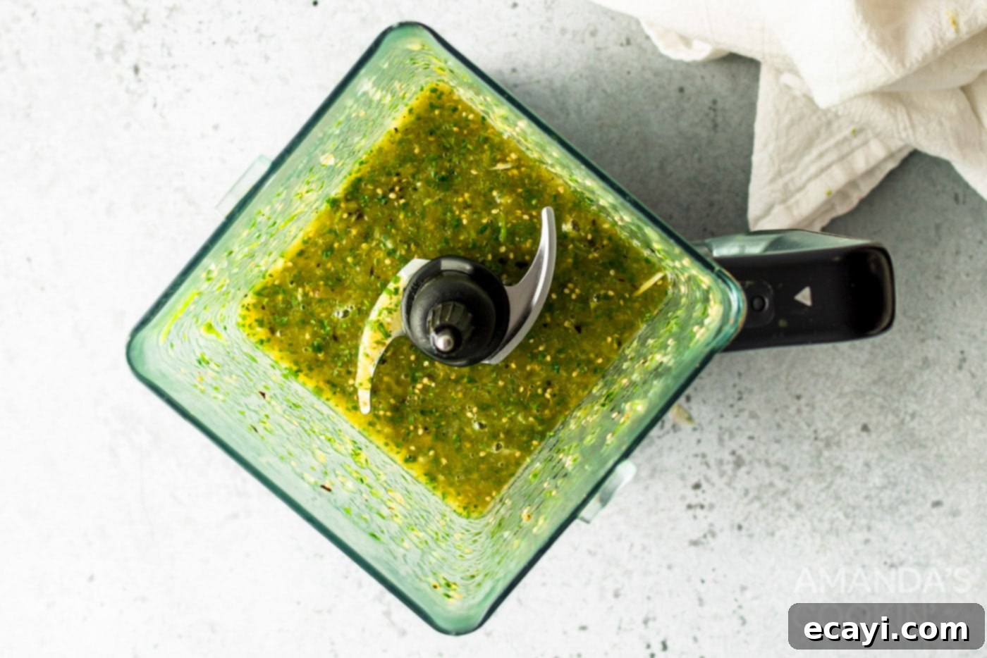 Green Salsa 7 A top-down view of vibrant green salsa in a blender, perfectly blended and ready for serving, showcasing its rich texture and color.