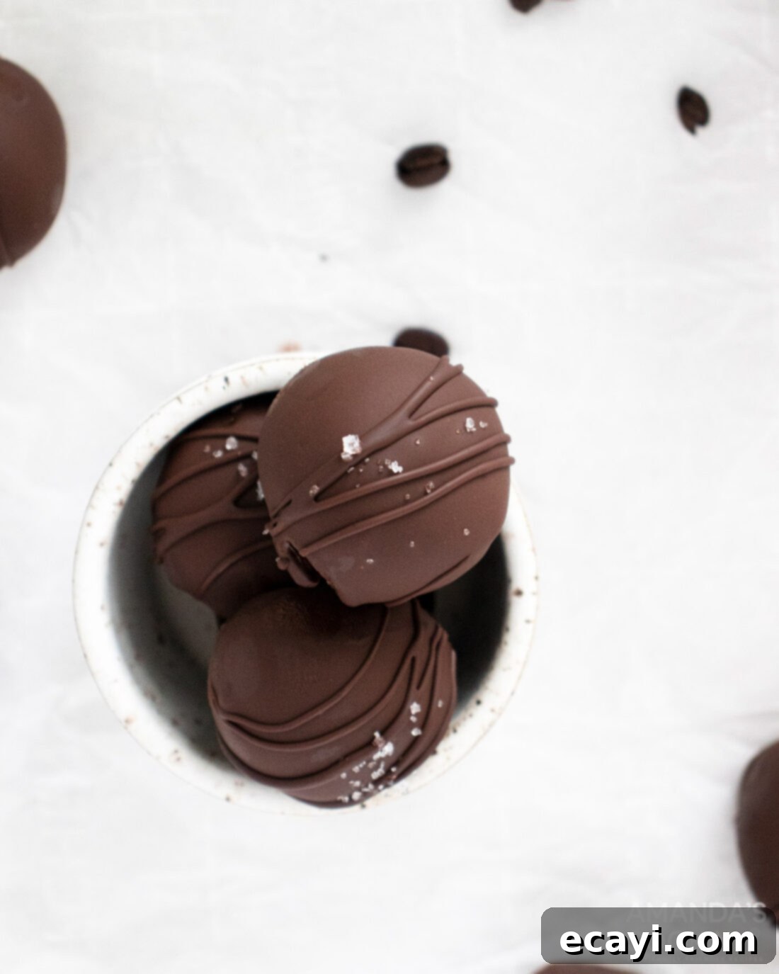 Decadent Mocha Truffles 9 An overhead shot of a decorative dish filled with an abundance of glossy, chocolate-coated mocha truffles, perfectly presented.