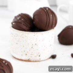Decadent Mocha Truffles 10 A close-up of several mocha truffles, beautifully coated and decorated, in a white bowl.