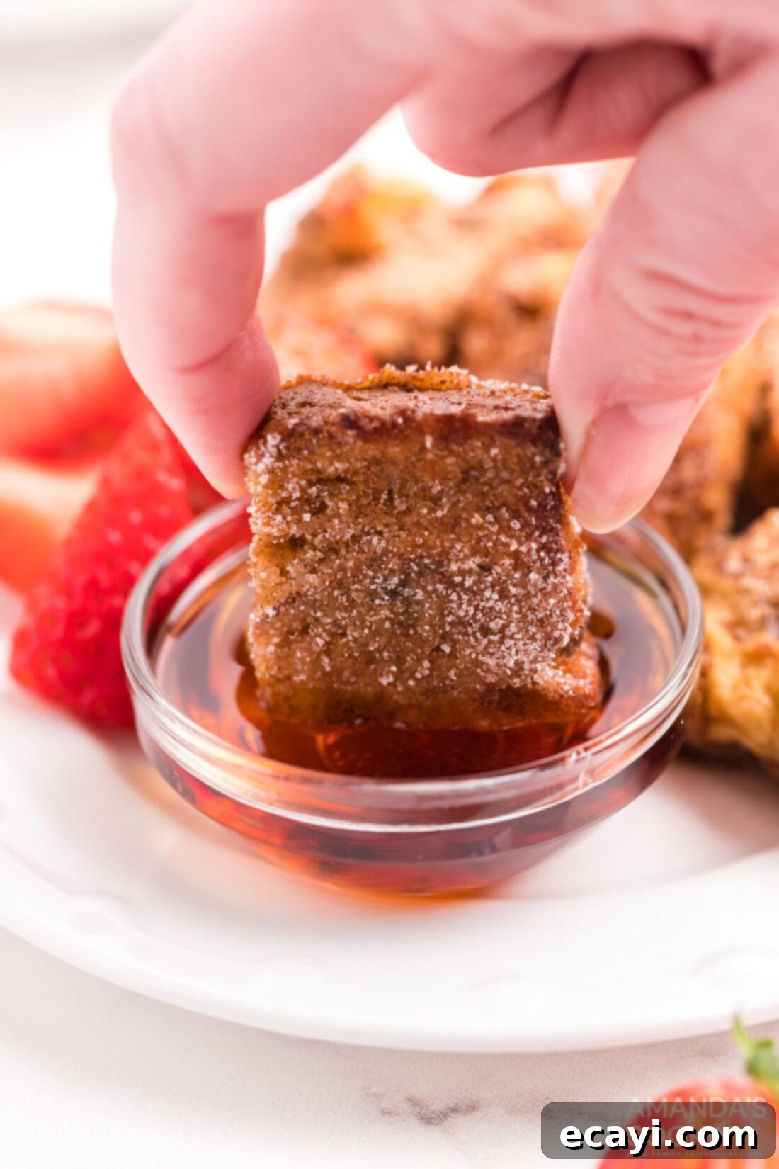 Crispy Air Fryer French Toast Bites 2 dipping a french toast stick in syrup
