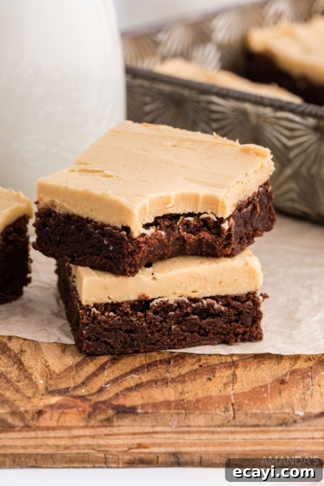 Irresistible Peanut Butter Fudge Brownies 3 Close-up of two fudge brownies with peanut butter frosting, one with a bite taken out, showing the fudgy interior