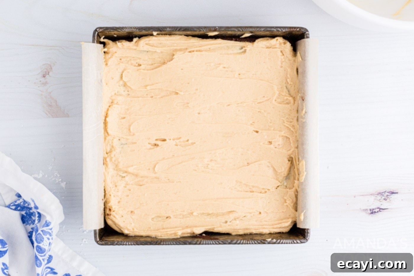 Irresistible Peanut Butter Fudge Brownies 10 Thick, creamy peanut butter frosting being spread evenly over cooled, fudgy brownies in a pan