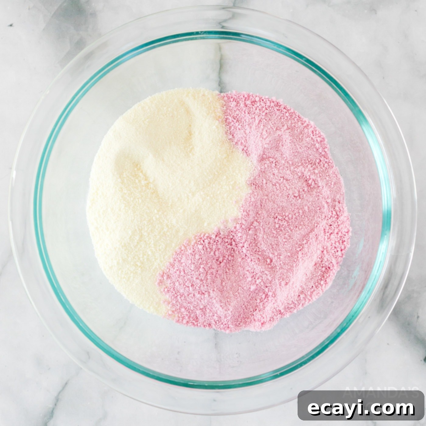 Dreamy Strawberry White Chocolate Hot Cocoa Bombs 5 A bowl containing a pink mixture of strawberry drink mix and powdered milk, ready for use in the hot cocoa bombs.