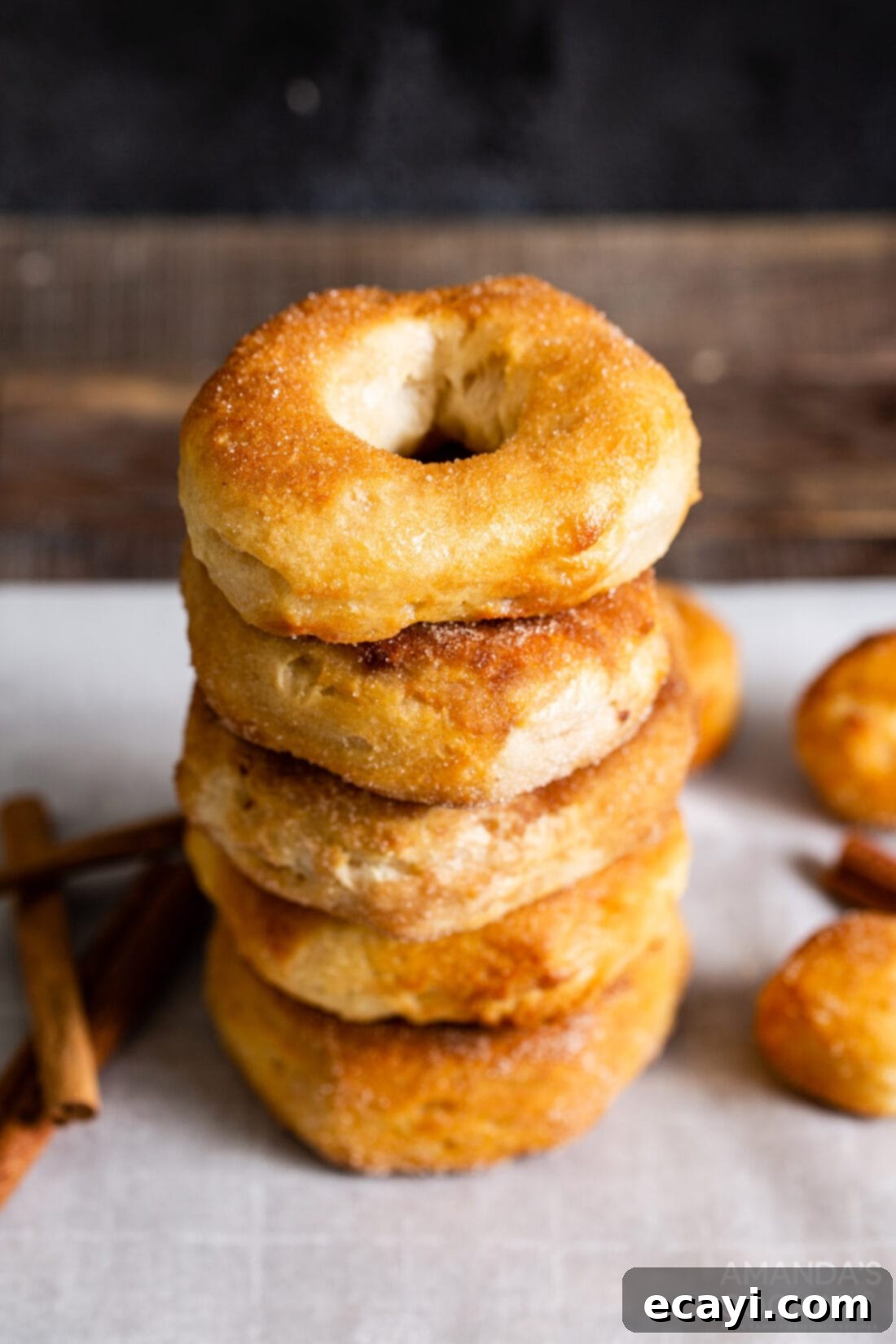 Air Fryer Donut Delights 10 A delightful stack of golden-brown air fryer donuts, generously coated in sweet cinnamon sugar.