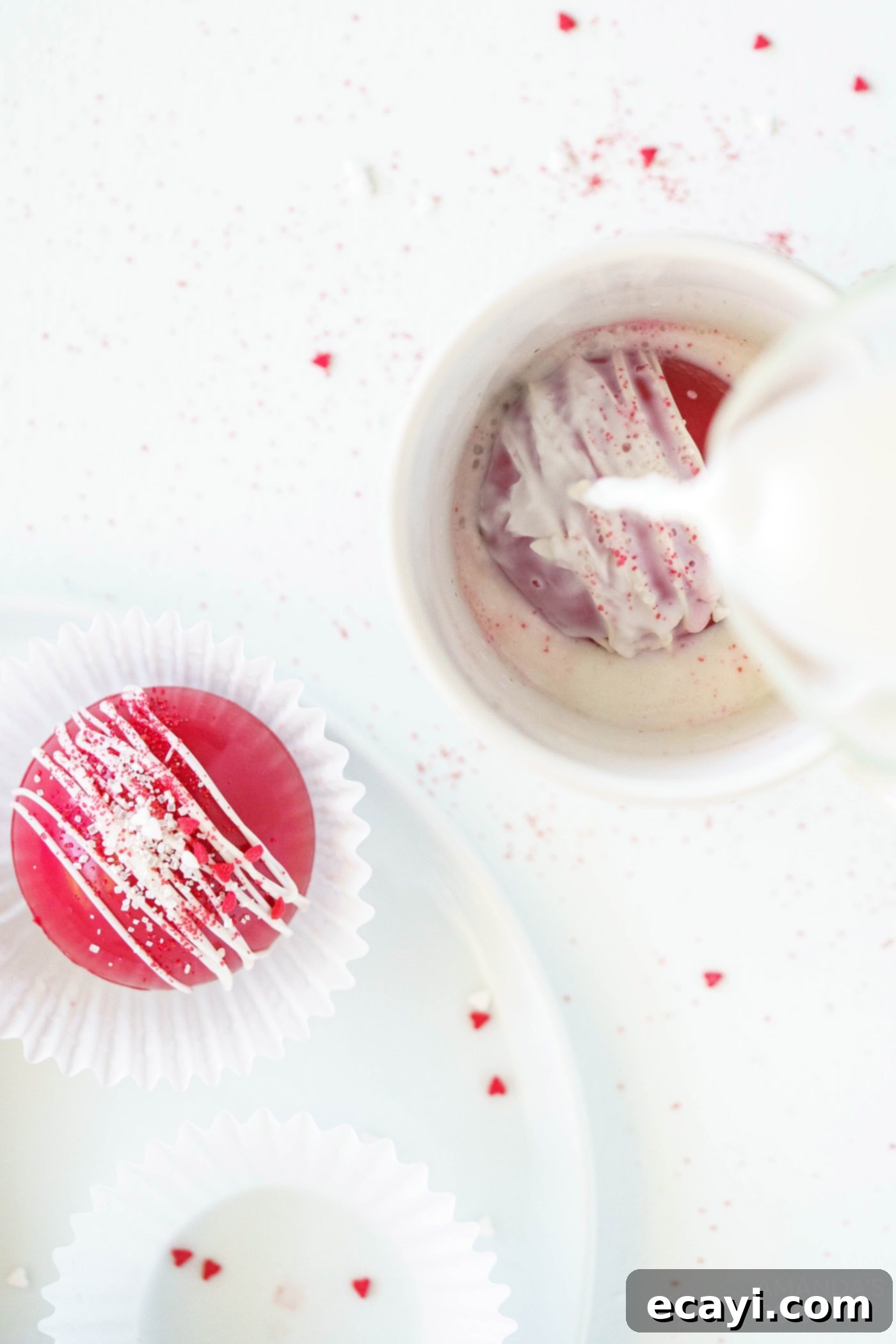 Decadent Red Velvet Hot Cocoa Bombs 14 A mug with a red velvet cocoa bomb, and hot milk being poured over it to activate the hot chocolate.