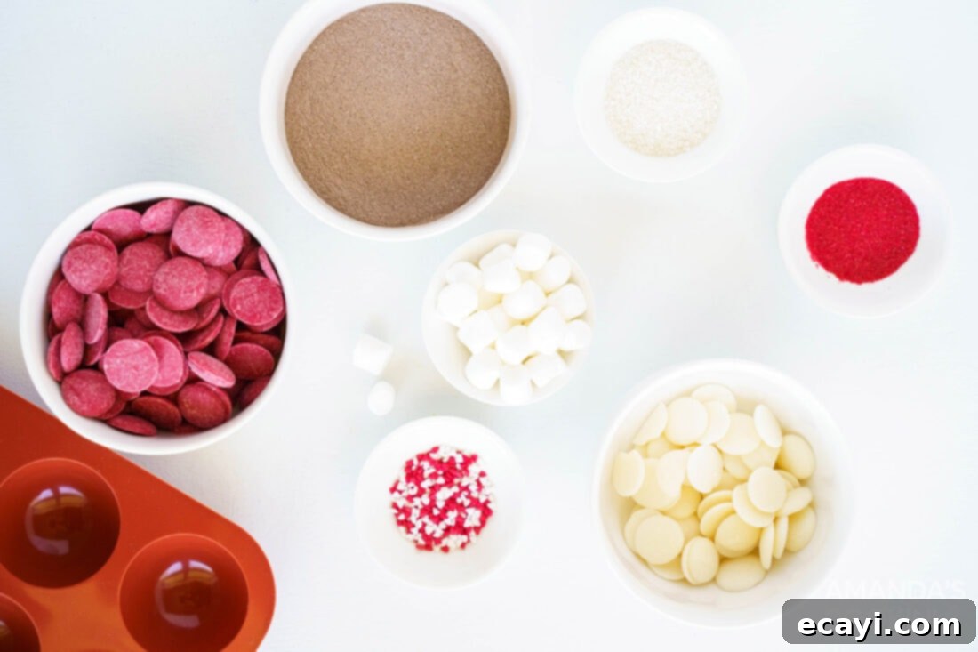 Decadent Red Velvet Hot Cocoa Bombs 4 A flat lay photograph of all the ingredients laid out on a surface for making red velvet hot cocoa bombs, including candy melts, hot cocoa mix, and sprinkles.