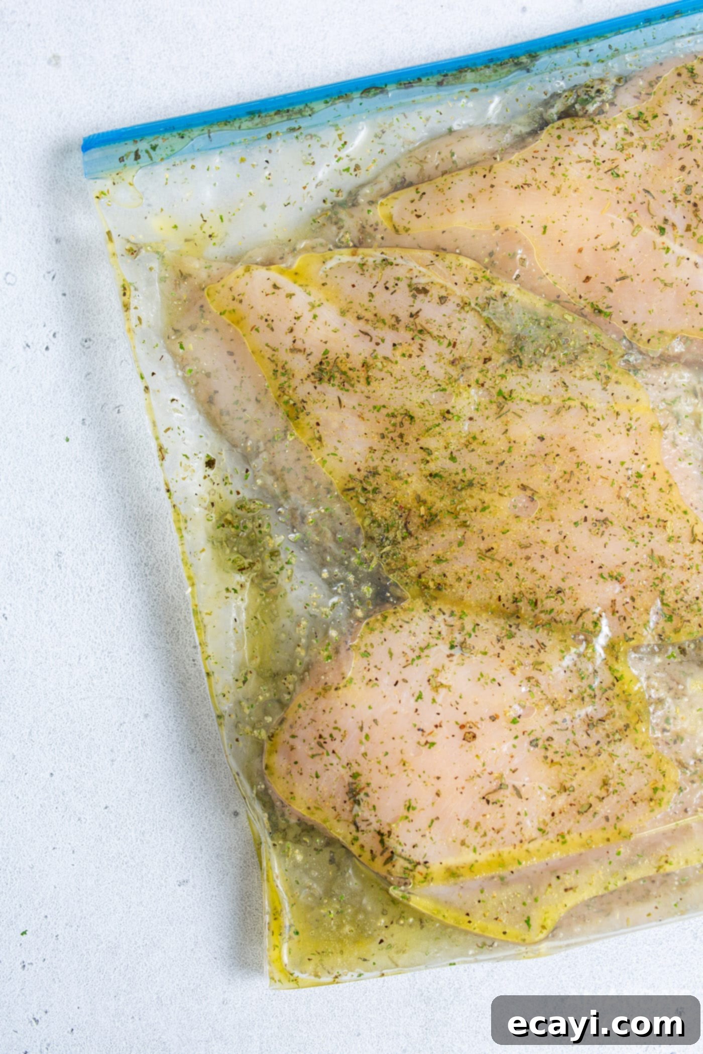 Perfect Air Fryer Chicken Breasts 5 Raw chicken breasts generously coated with a savory seasoning blend inside a sealed plastic bag.