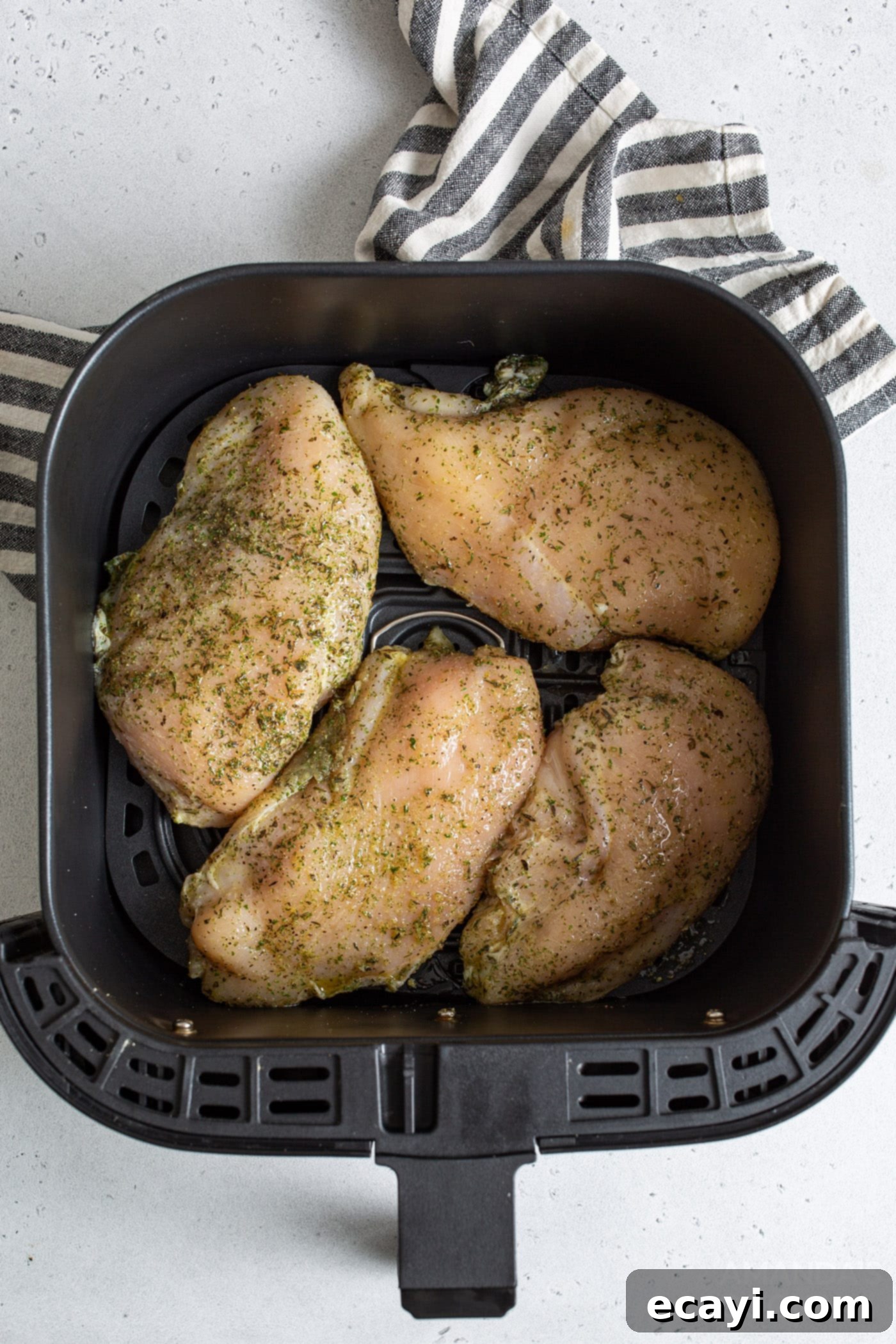 Perfect Air Fryer Chicken Breasts 6 Raw, seasoned chicken breasts placed in a single layer within the air fryer basket, ready for cooking.