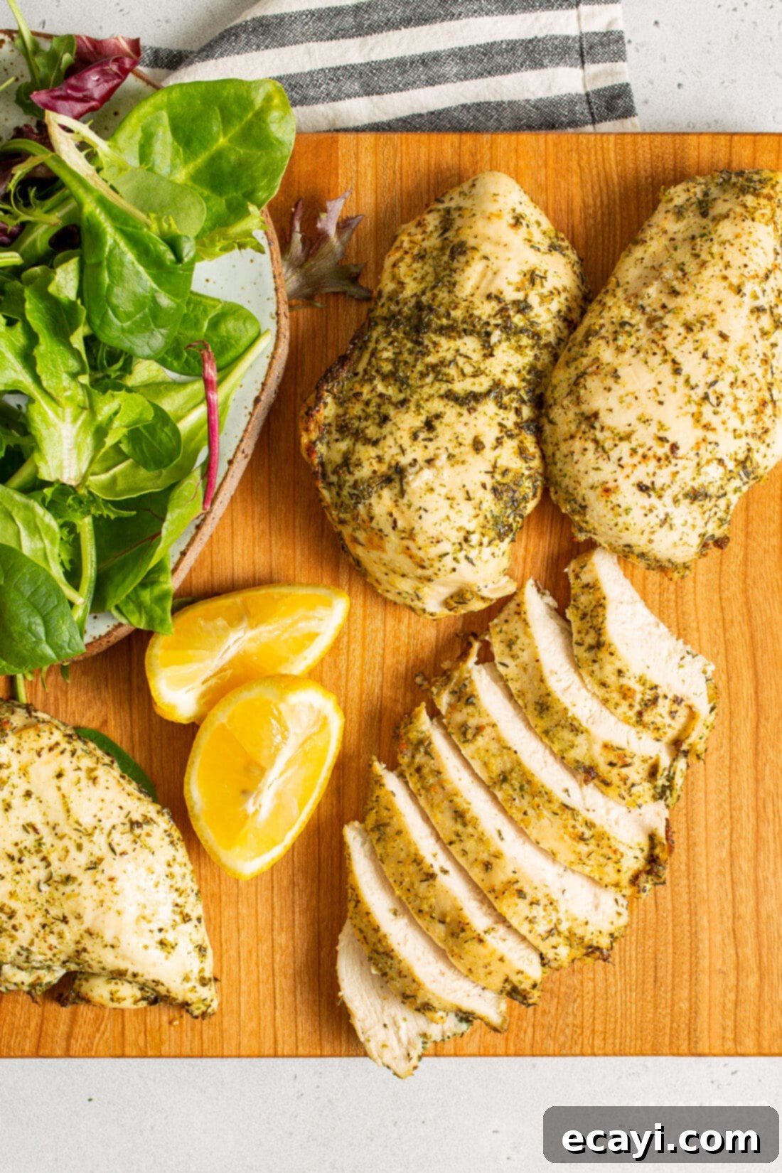 Perfect Air Fryer Chicken Breasts 8 Close-up of perfectly cooked and sliced chicken breasts on a wooden cutting board, showcasing their juicy texture.