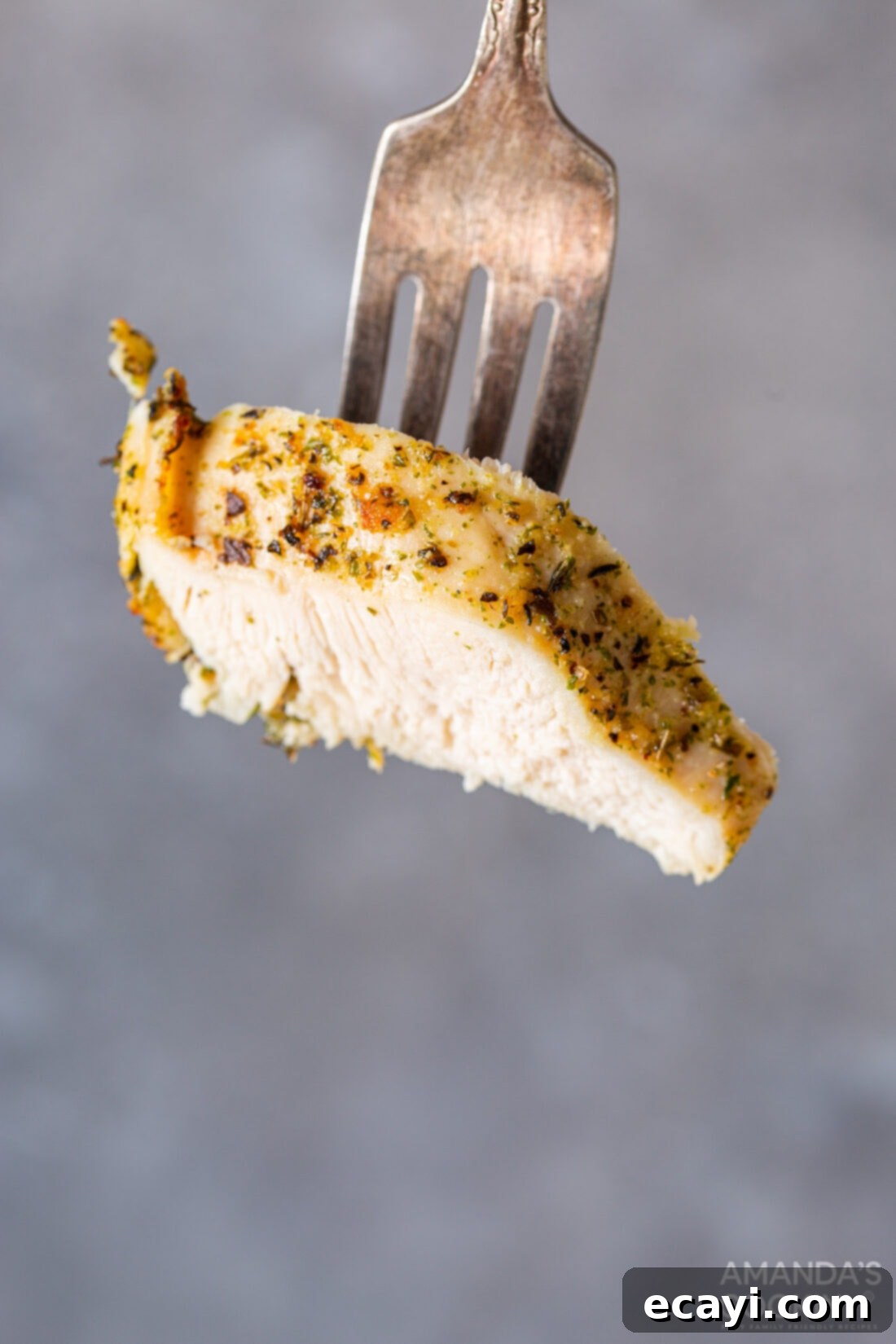 Perfect Air Fryer Chicken Breasts 9 A fork holding a piece of perfectly cooked and juicy air fryer chicken, ready to be enjoyed.