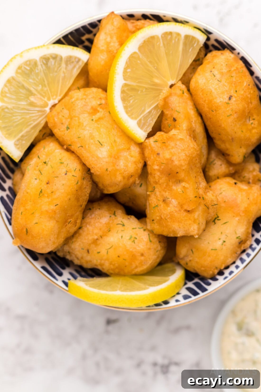 Crispy Golden Beer-Battered Fish 3 Close-up of golden-brown beer battered fish nuggets piled in a rustic metal bowl, ready for serving.