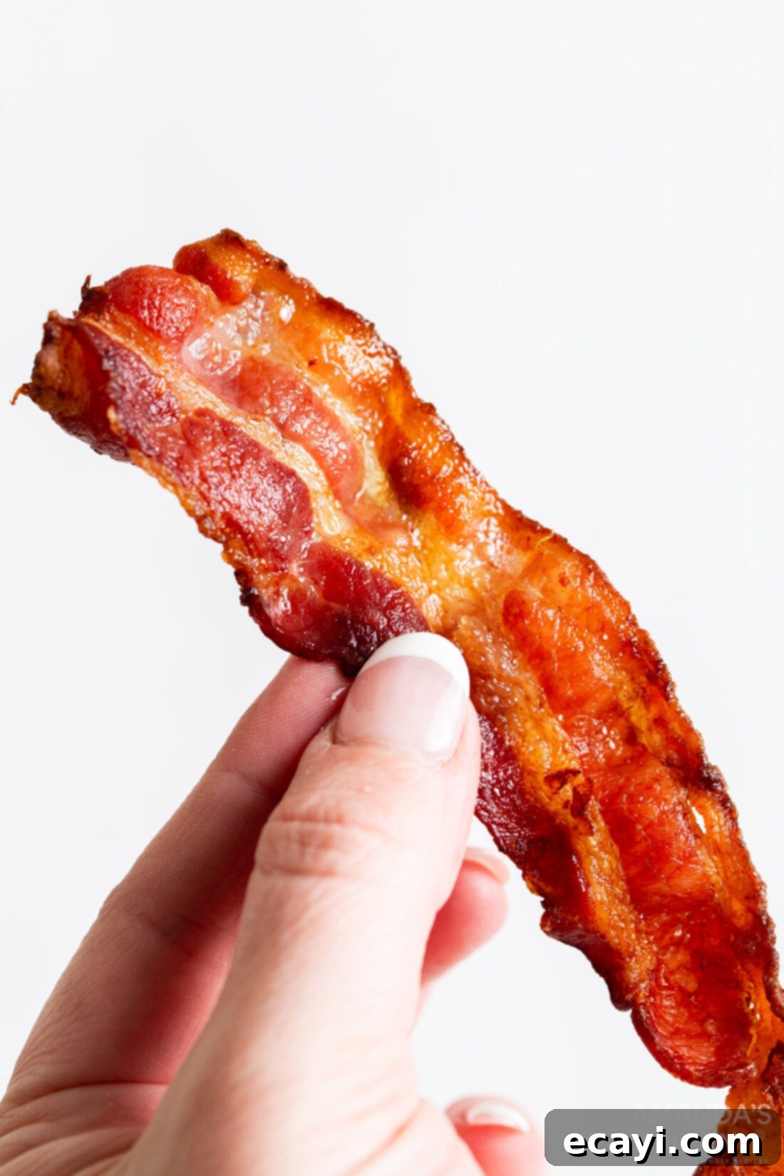 Effortless Crispy Air Fryer Bacon 2 woman holding slice of bacon