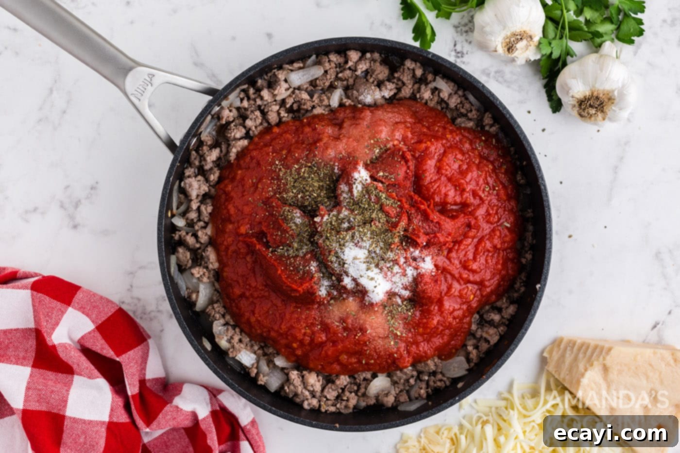 Effortless Crockpot Lasagna 5 tomato sauce on top of cooked meat in a skillet