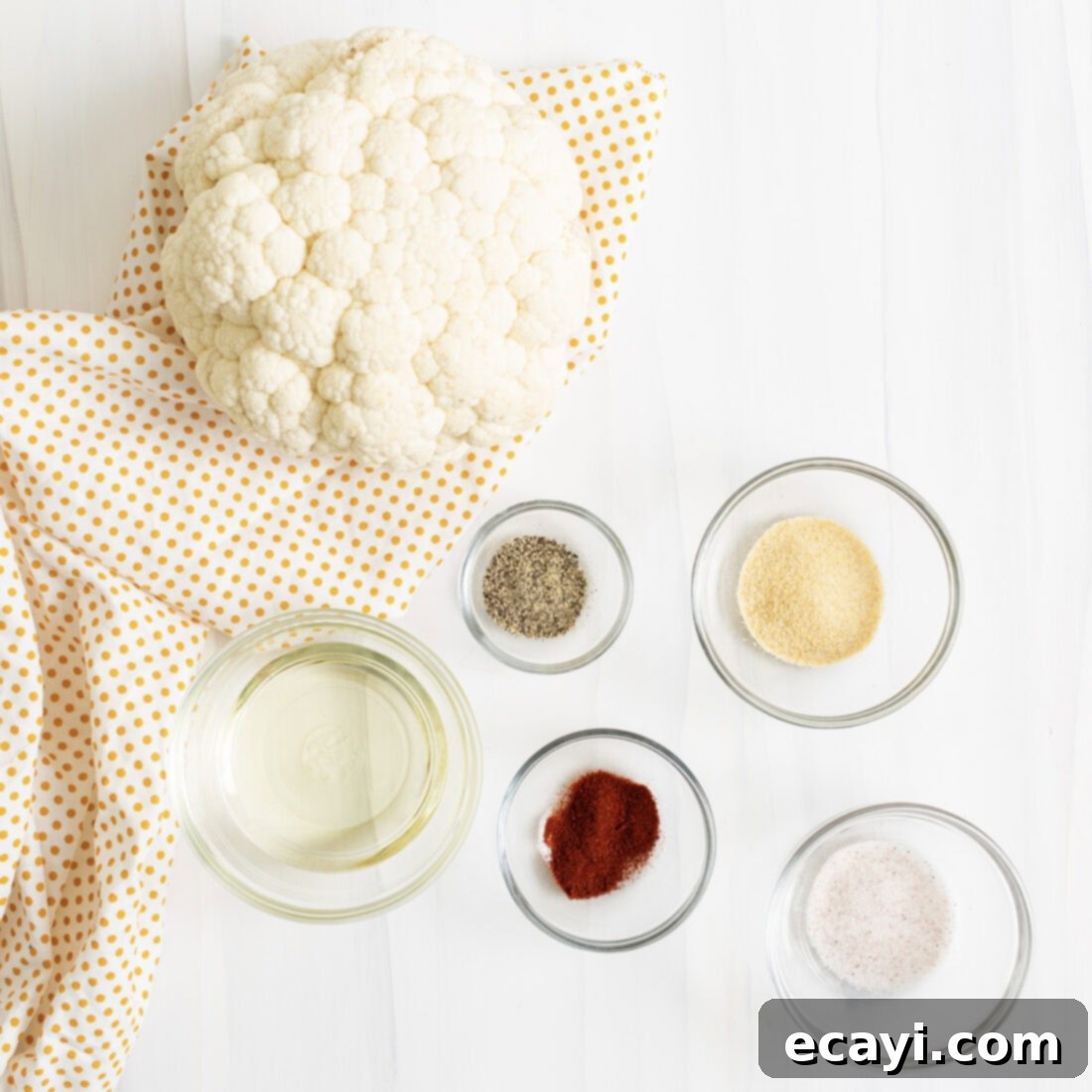 Crispy Air Fryer Cauliflower 4 Ingredients for Air Fryer Cauliflower, including a head of cauliflower, oil, and spices