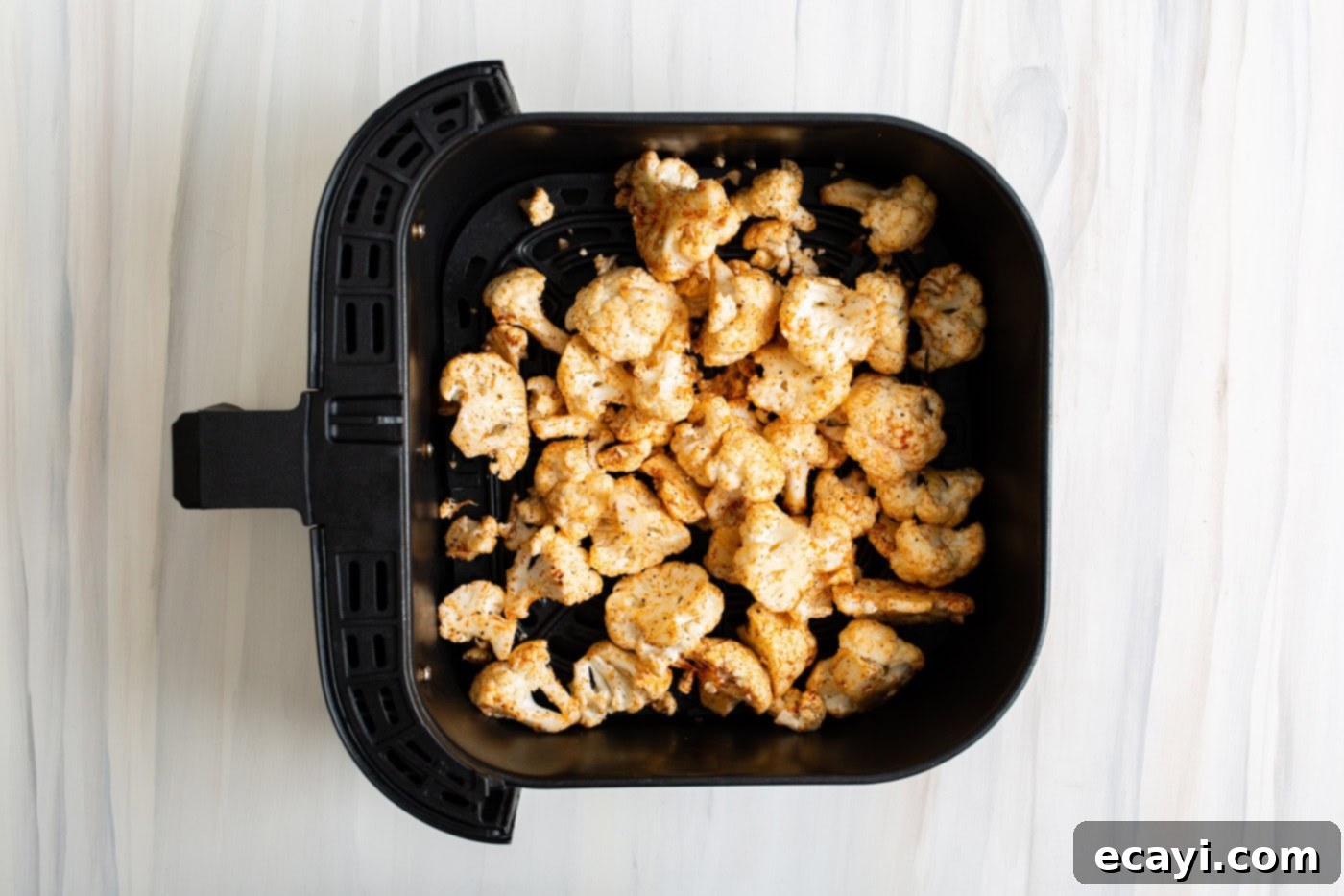Crispy Air Fryer Cauliflower 7 Seasoned cauliflower in an air fryer basket