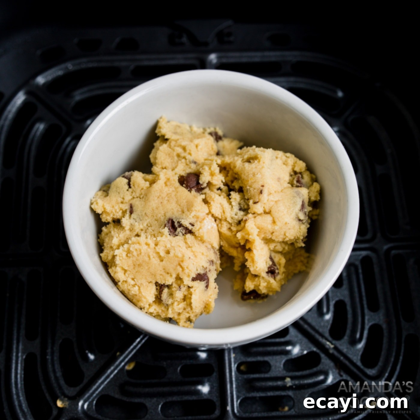 Your Air Fryer's Best Chocolate Chip Cookies 11 Chocolate chip cookie dough scooped into a white ramekin, ready for air frying