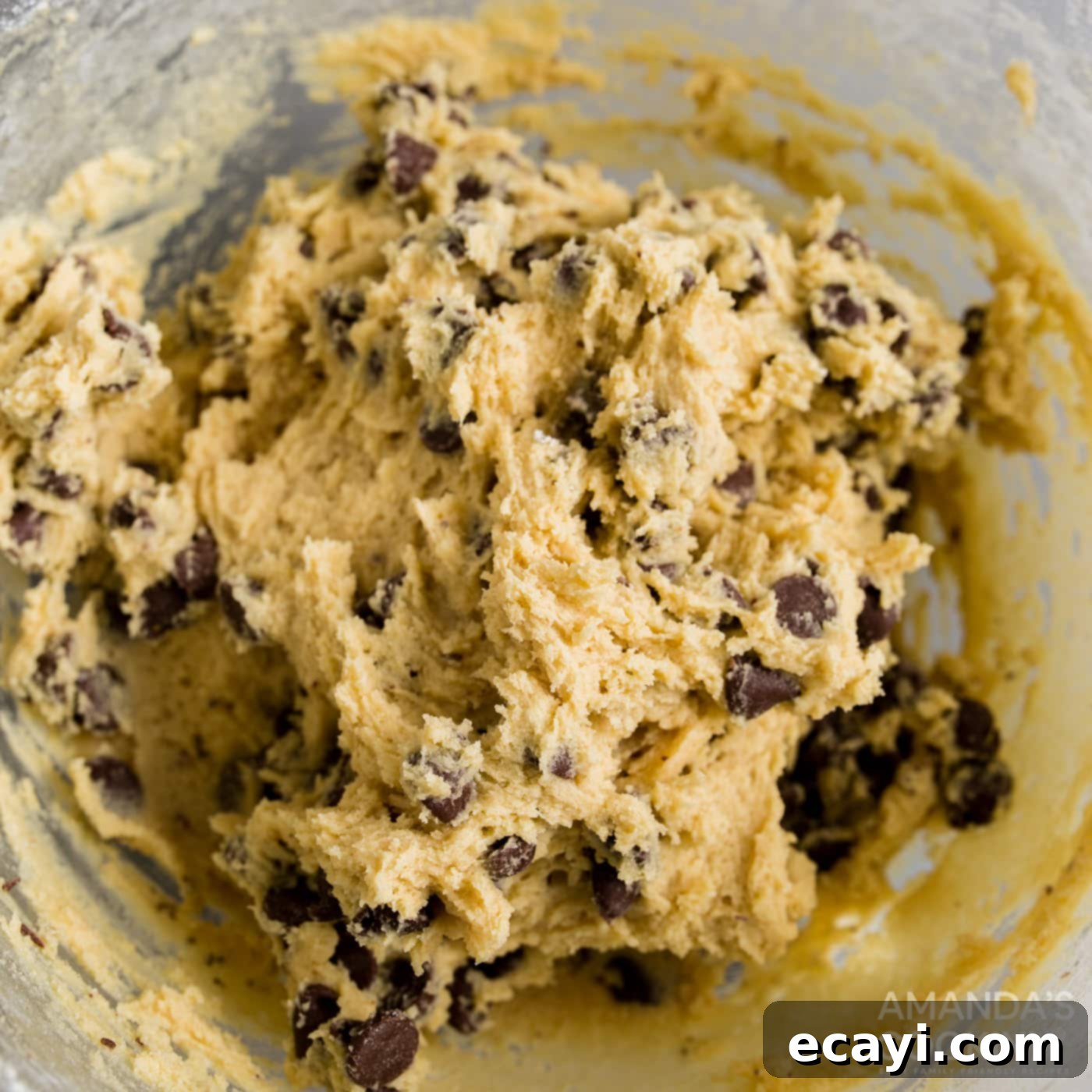 Your Air Fryer's Best Chocolate Chip Cookies 8 Folding chocolate chips into cookie dough in a mixing bowl with a spatula