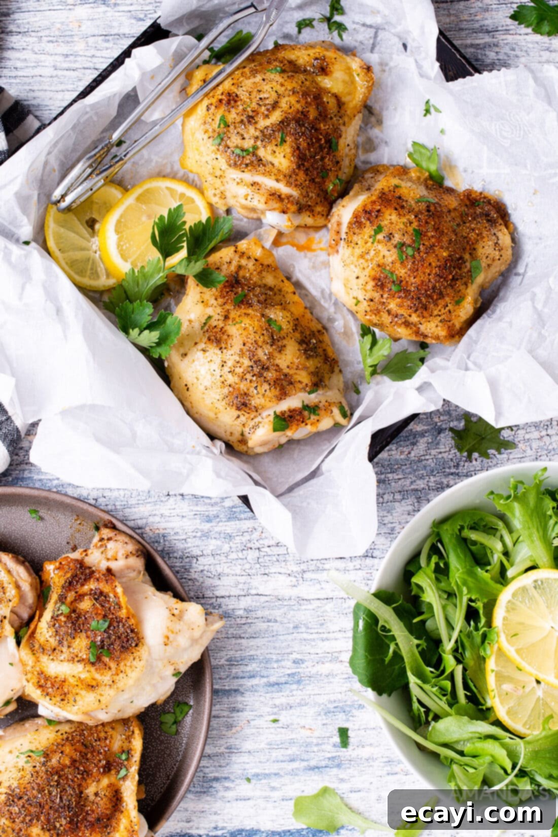 Crispy Air Fryer Chicken Thighs 3 Air fried chicken thighs served in a square dish alongside a fresh green salad, highlighting a complete and healthy meal idea.