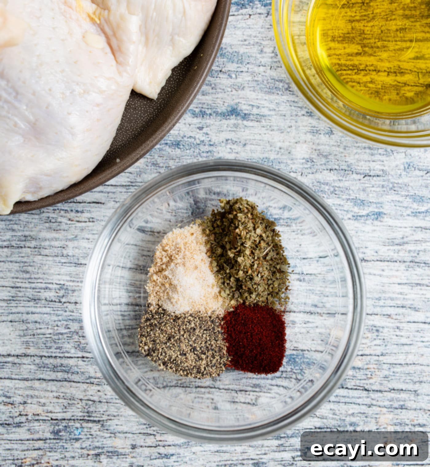 Crispy Air Fryer Chicken Thighs 5 A small bowl containing a mixed blend of paprika, garlic salt, marjoram, and black pepper, ready for seasoning.
