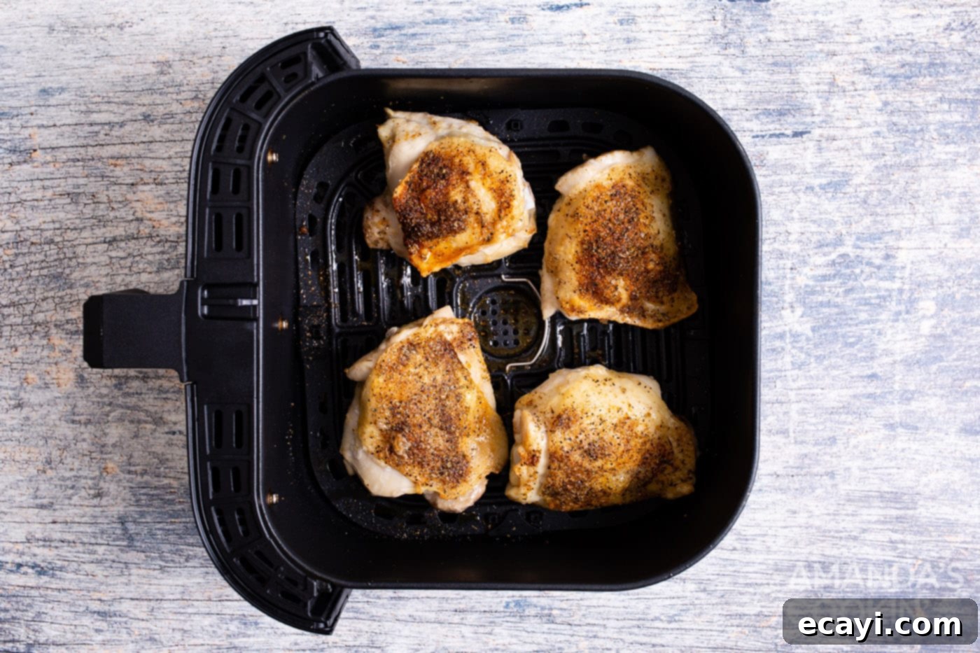 Crispy Air Fryer Chicken Thighs 8 Crispy, golden brown air fryer chicken thighs cooking in the air fryer basket, showcasing perfect results and texture.