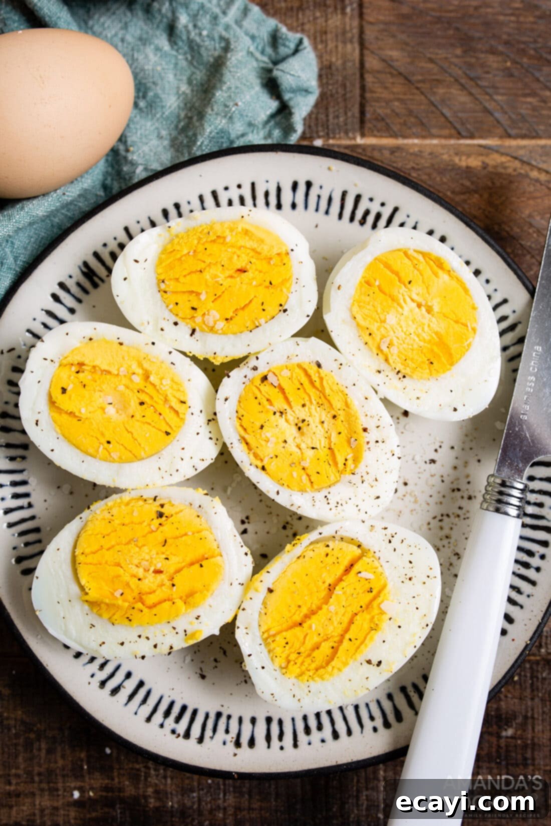Hard Boiled Eggs in the Air Fryer 2 halved hard boiled eggs on a plate, perfectly cooked with a firm yolk