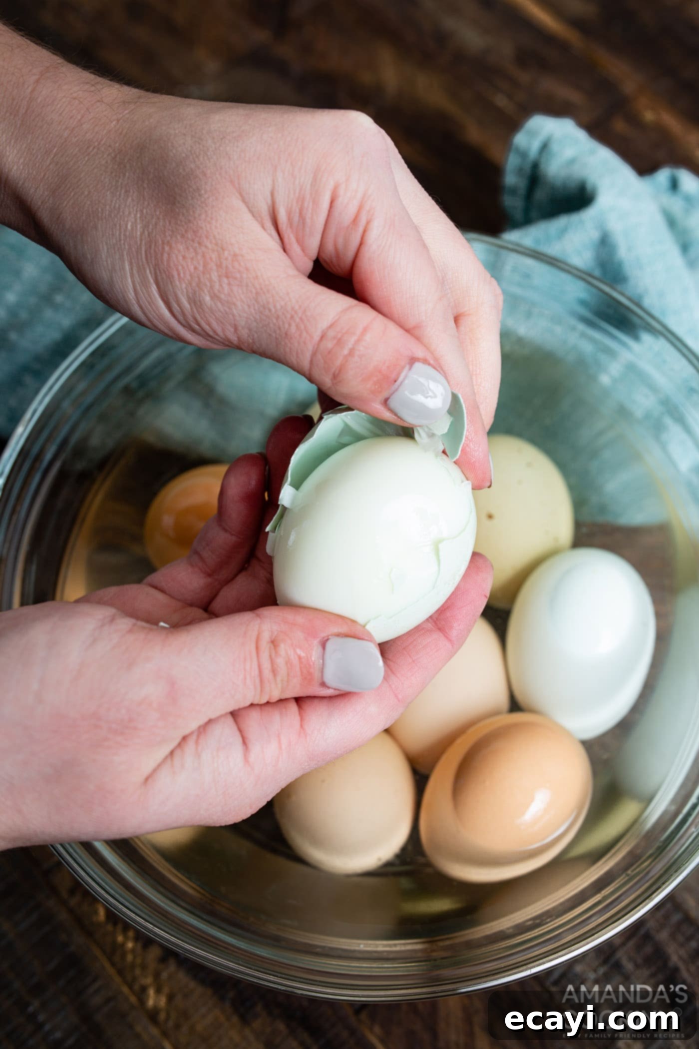 Hard Boiled Eggs in the Air Fryer 6 A hand peeling a hard boiled egg