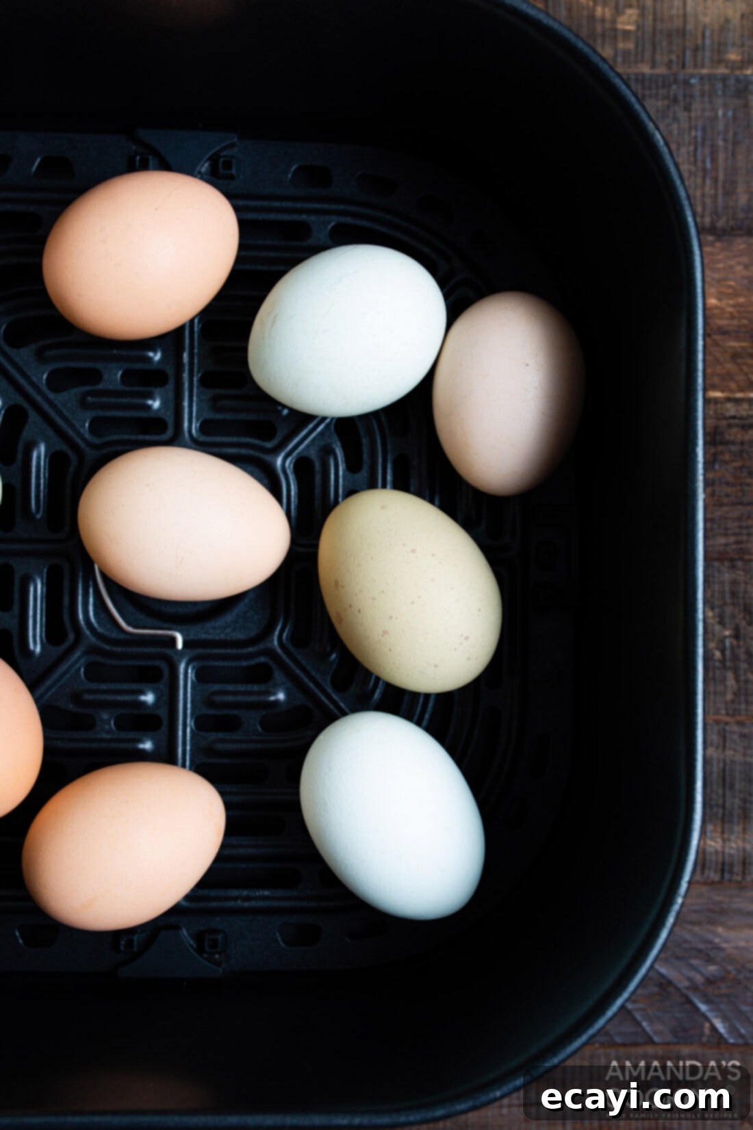 Hard Boiled Eggs in the Air Fryer 8 eggs neatly arranged in an air fryer basket, ready for cooking