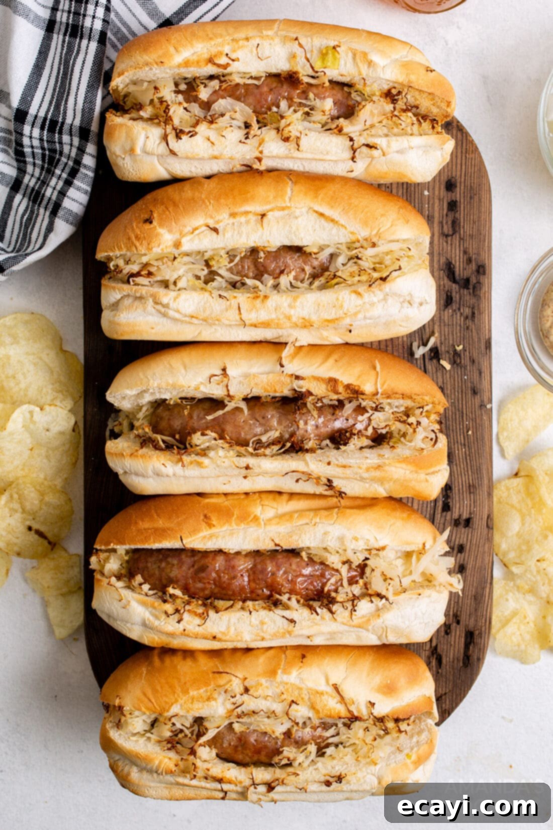 Crispy Air Fryer Bratwurst 2 air fryer bratwurst in buns with sauerkraut on cutting board