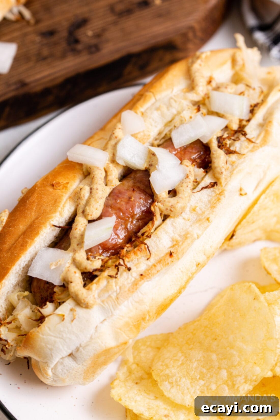 Crispy Air Fryer Bratwurst 9 air fryer bratwurst on a bun with sauerkraut, mustard and onion