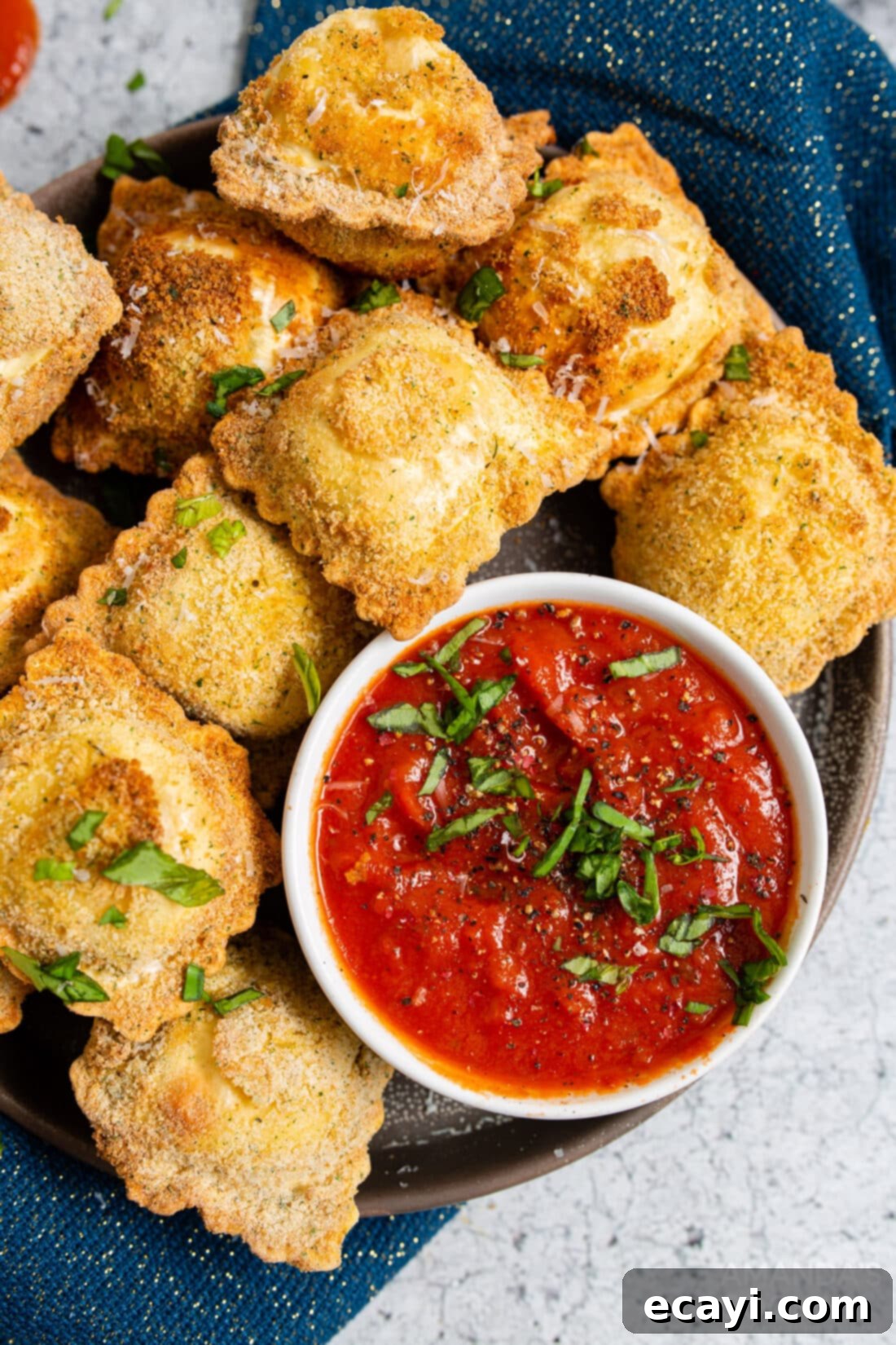 Crispy Air Fryer Ravioli 2 Plate of golden brown crispy air fryer ravioli served with a side of marinara sauce