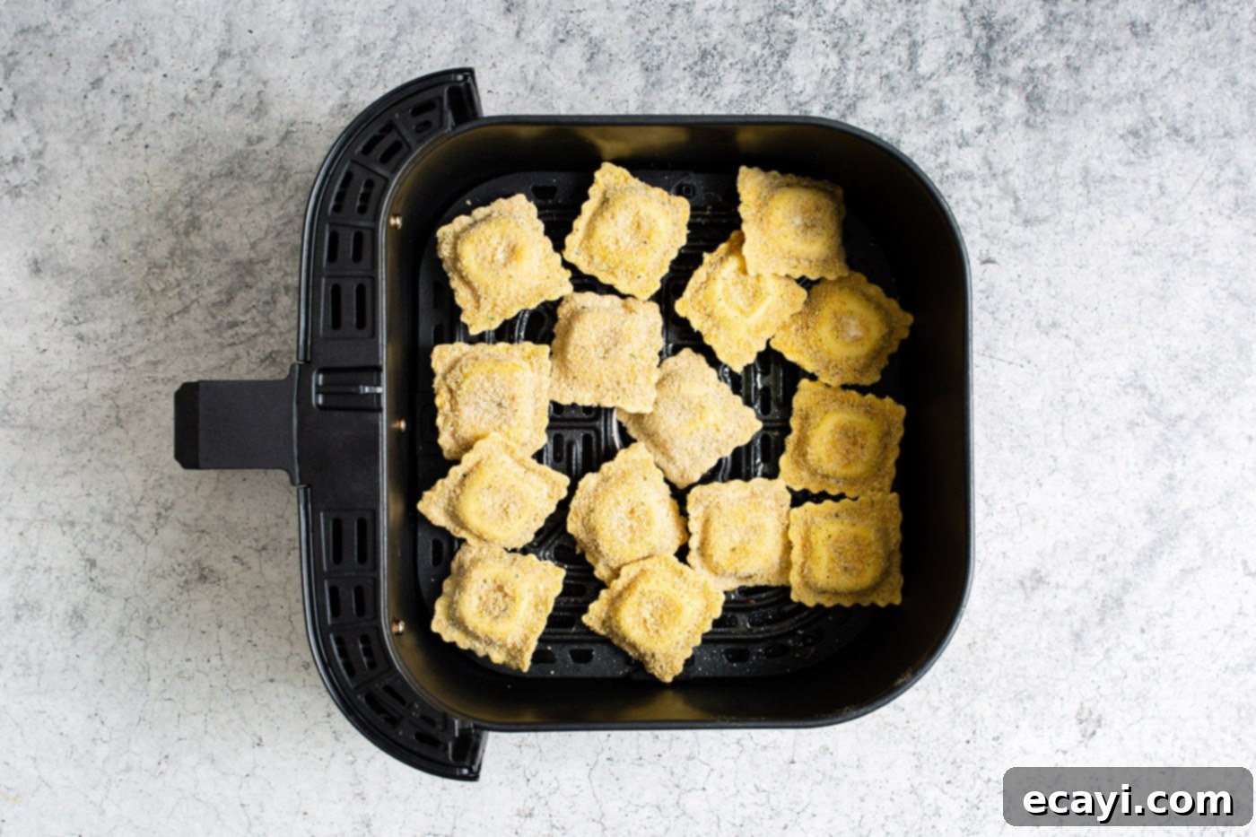 Crispy Air Fryer Ravioli 10 Crispy air fried ravioli cooking in an air fryer basket