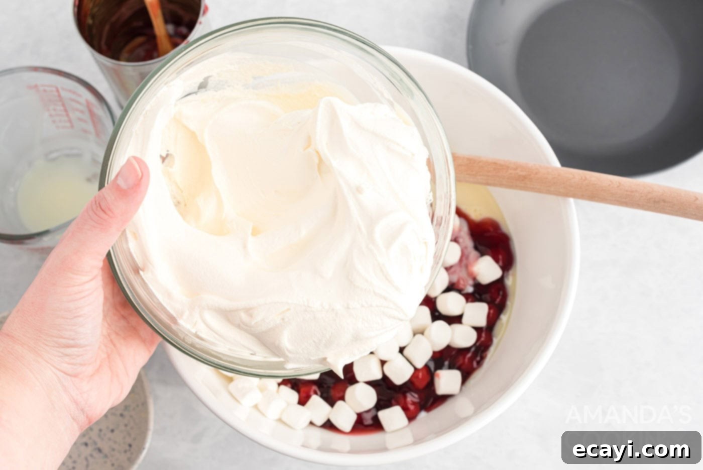 Crimson Cloud 5 Adding cool whip to other ingredients in a bowl